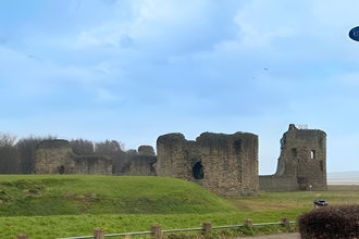 Blue sky Flint castle with whale tail sculpture