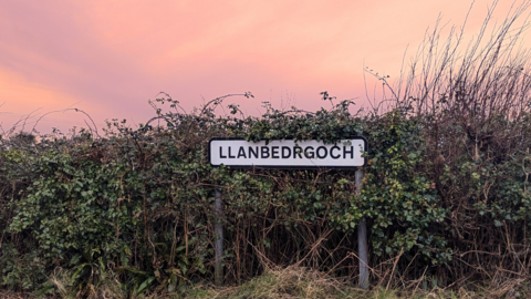 Llanbedrgoch road sign with a pink sky