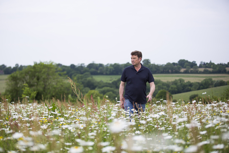 Nick Rowsell, a farmer for Jordans Cereals, walks through a field of wildflowers