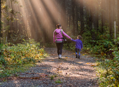 Image of woman and girl walking in forest